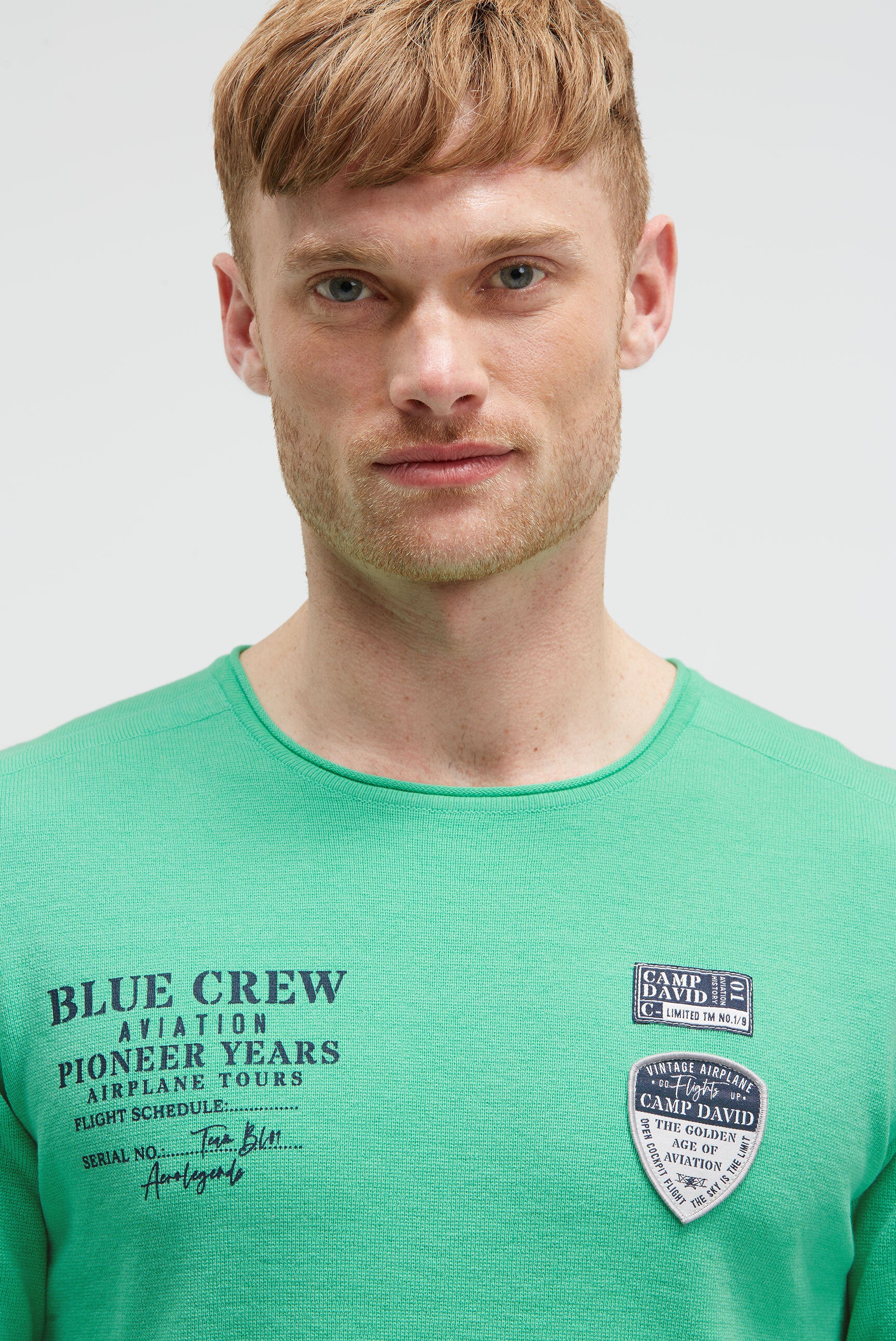 Sweter z nadrukiem, naszywkami i kieszenią na rękawie