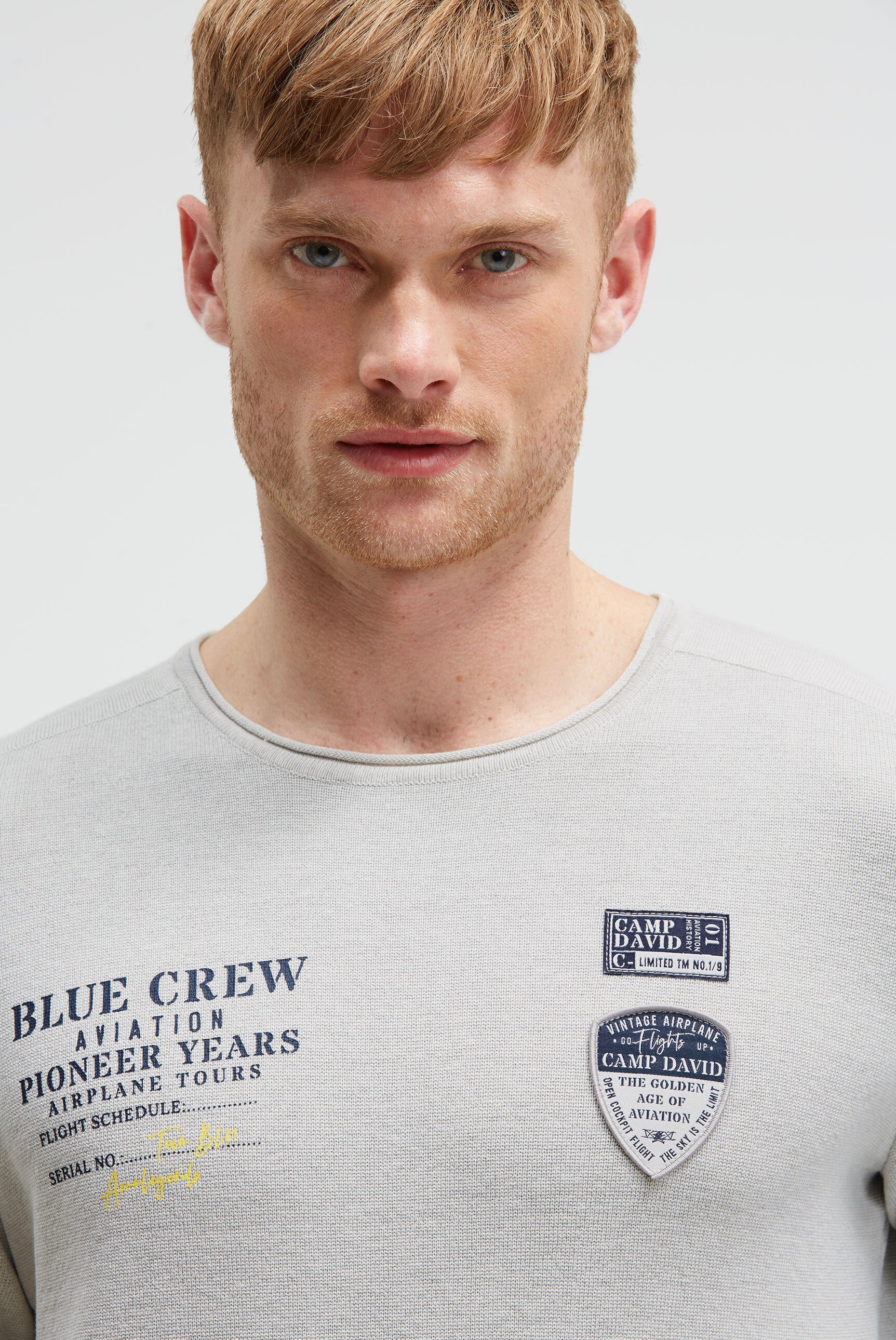 Sweter z nadrukiem, naszywkami i kieszenią na rękawie