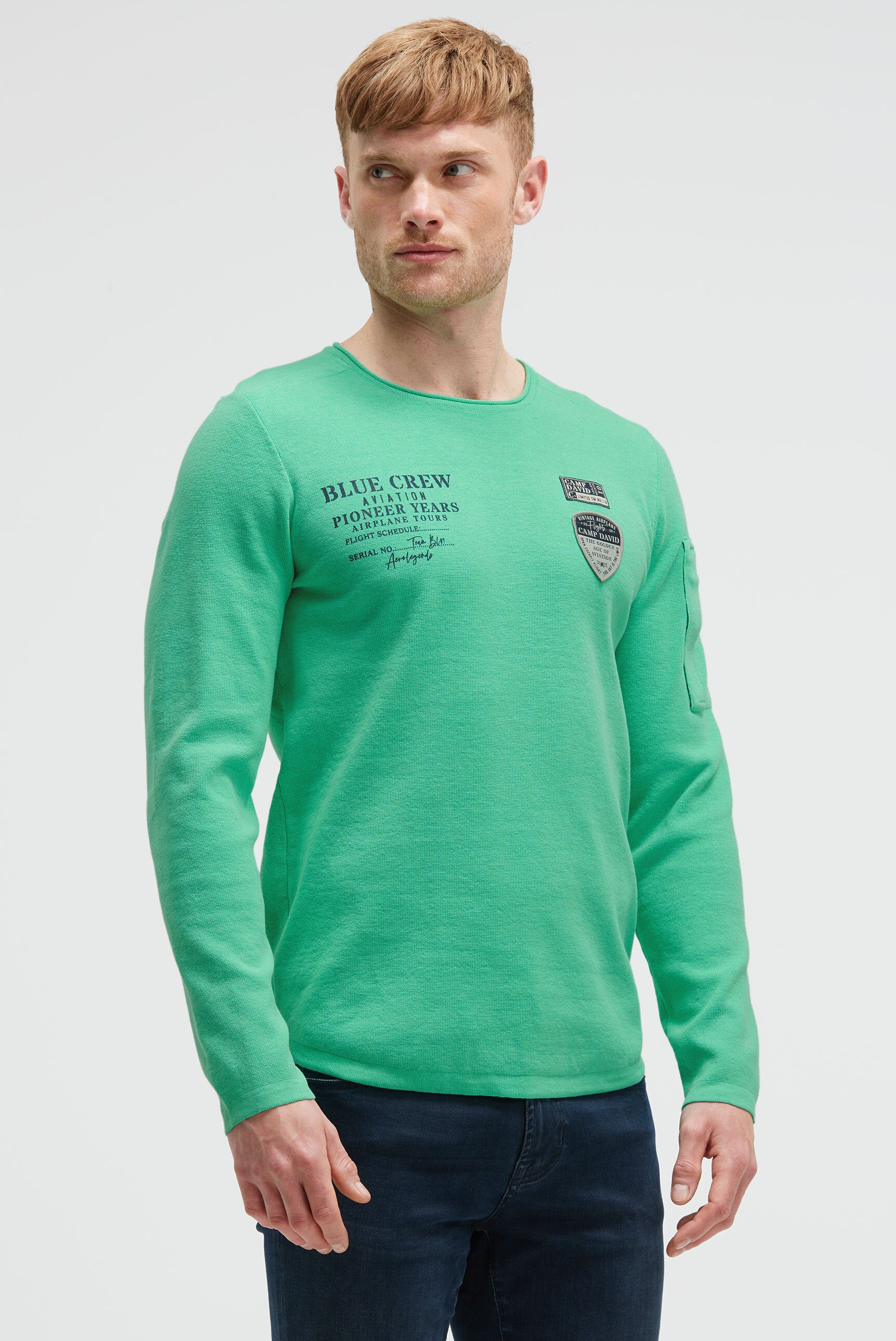 Sweter z nadrukiem, naszywkami i kieszenią na rękawie