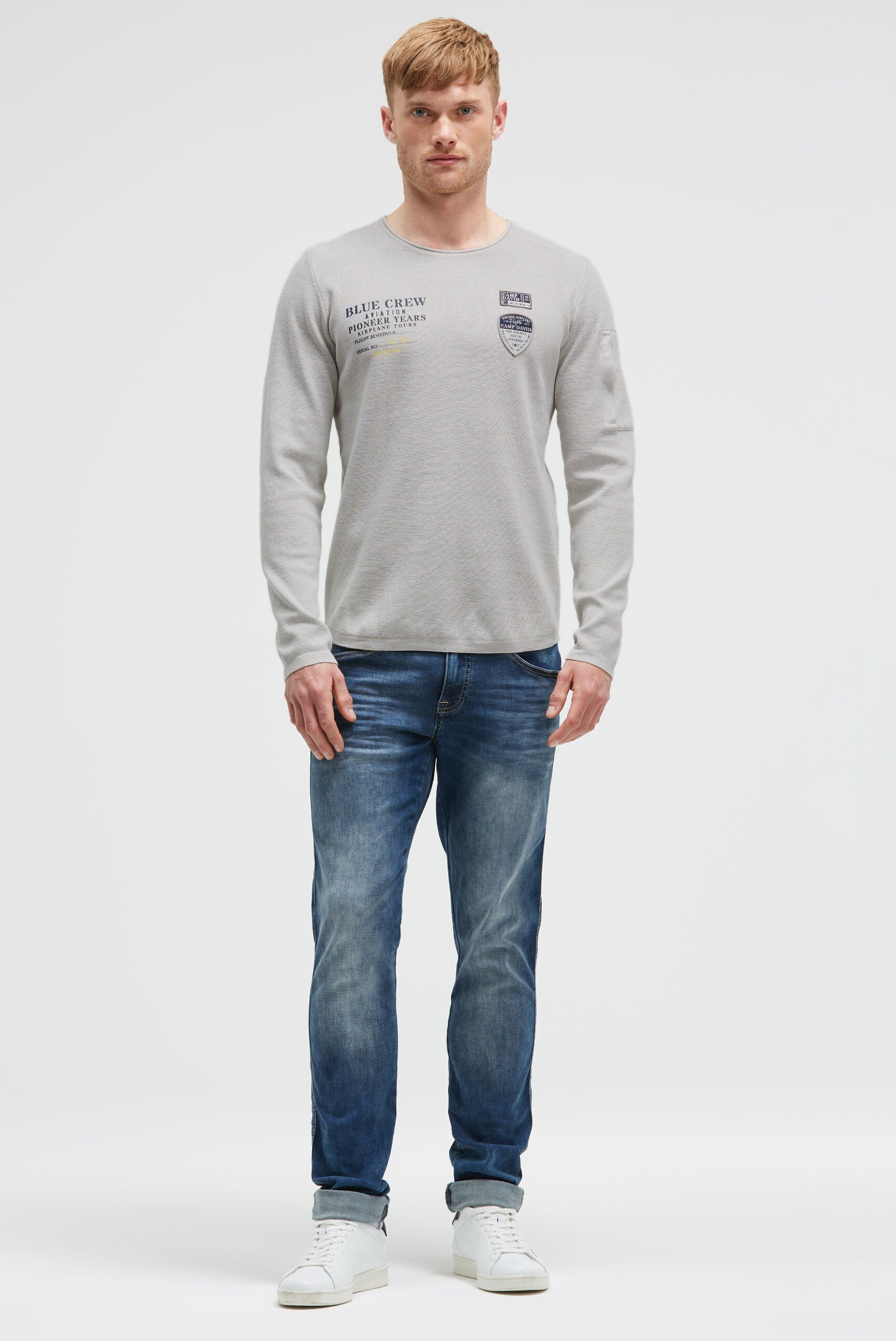 Sweter z nadrukiem, naszywkami i kieszenią na rękawie